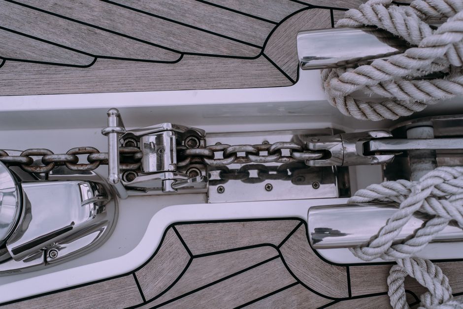 Detailed shot of sailboat deck featuring a chain and rope setup, ideal for marine themes.